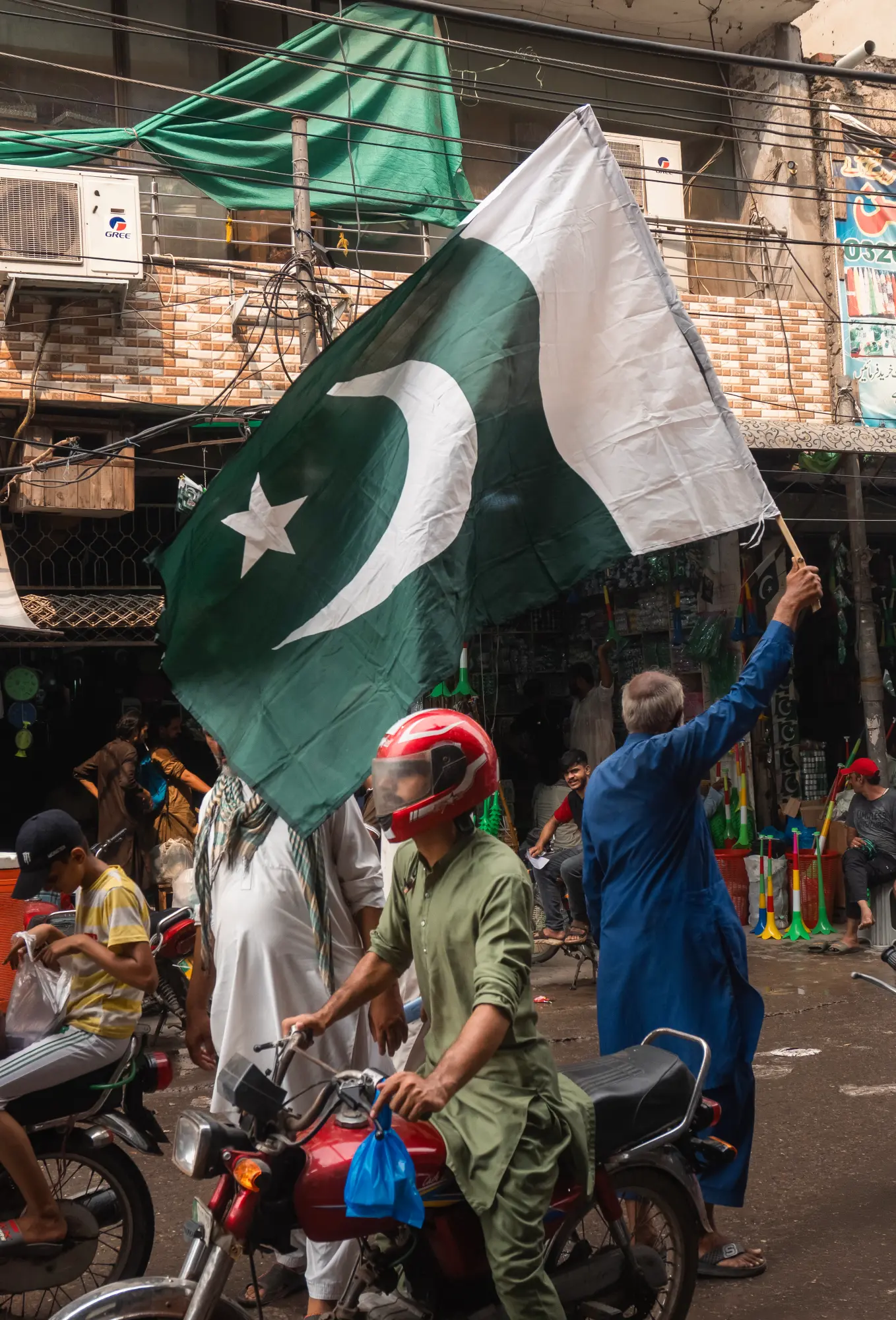 A man waves the Pakistani flag at Urdu Bazaar