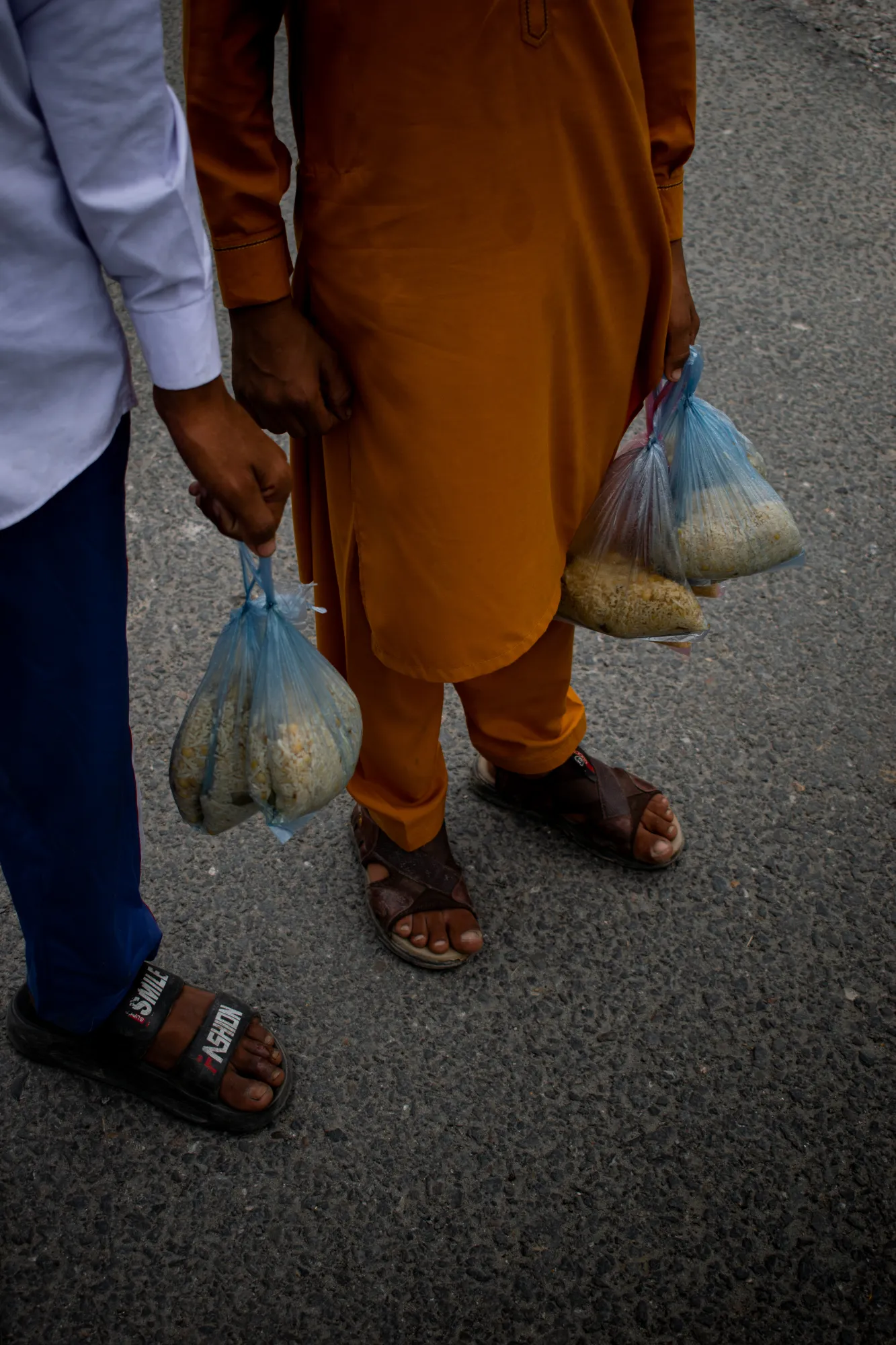 People carrying plastic bags of tabarakaat they have collected